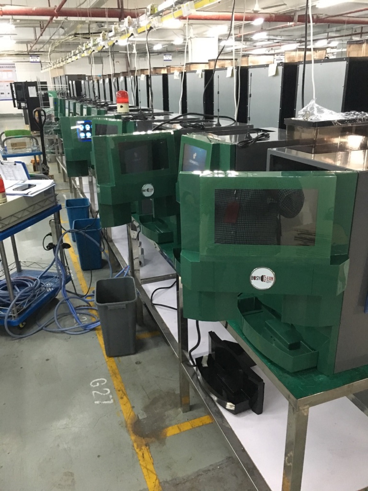 Close-up of Busy Bean Coffee machines on the assembly line with the brand logo visible
